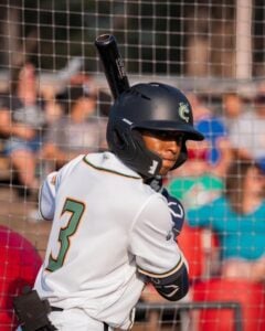 Baseball player wearing a helmet and uniform with the number 3, holding a bat.